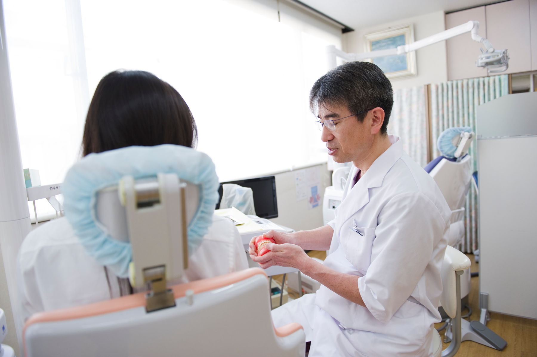 患者様へ入れ歯を説明する院長
